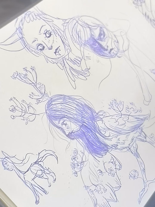 Open sketchbook showing blue ballpoint character concept drawings